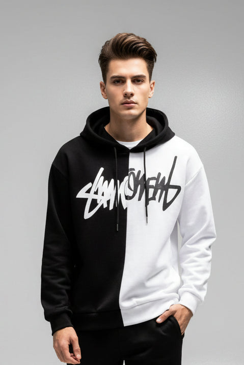 Person wearing a black and white hoodie with a brand logo on a dark background