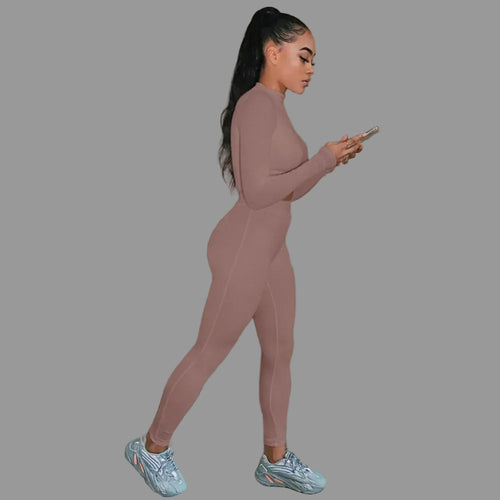 Woman in a pink tracksuit  looking at her phone.