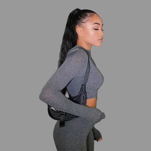 Woman in a gray outfit with a black bag 