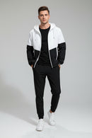 Man wearing a black and white color-blocked tracksuit on a gray background