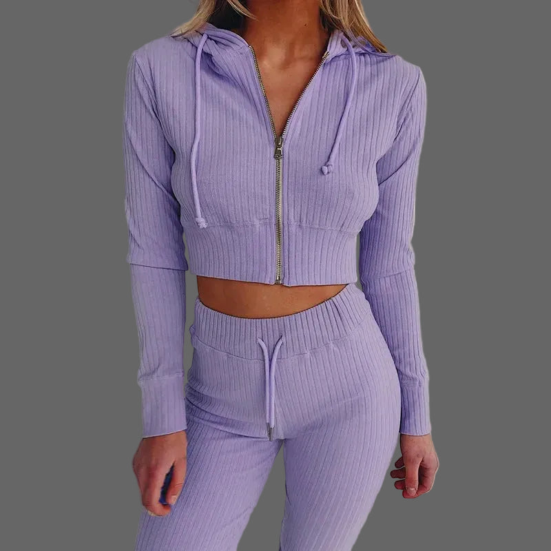 Person wearing a purple ribbed tracksuit on a white background