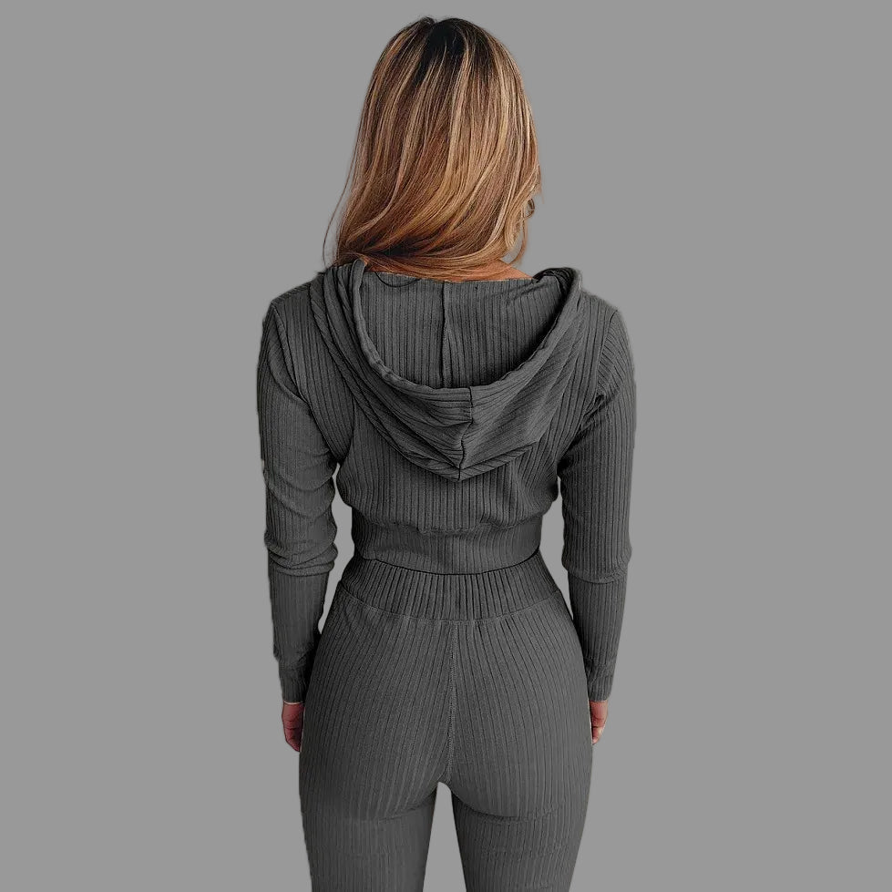 Person wearing a gray ribbed hoodie and pants set against a white background