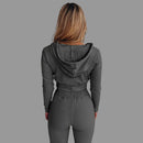 Person wearing a gray ribbed hoodie and pants set against a white background