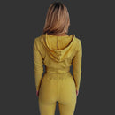 Person wearing a mustard yellow ribbed hoodie and pants set against a white background