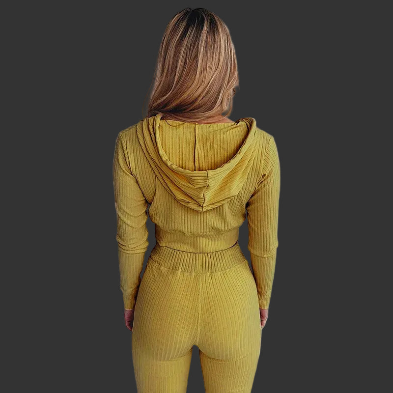 Person wearing a mustard yellow ribbed hoodie and pants set against a white background