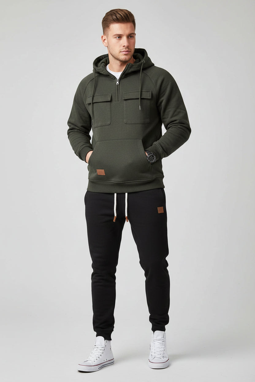 Dark gray hoodie and black pants with white sneakers on a gray background