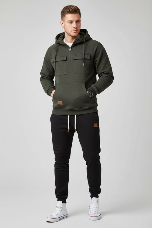 Dark gray hoodie and black pants with white sneakers on a gray background