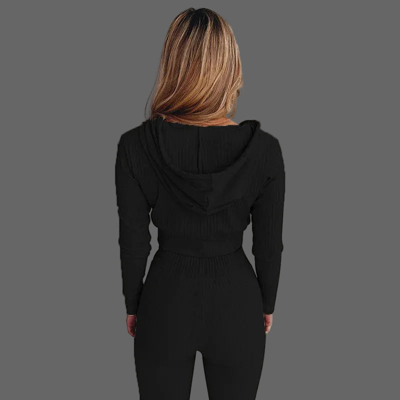 Person wearing a black hooded outfit against a white background
