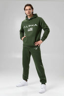 Person wearing a green Alpha tracksuit on a white background