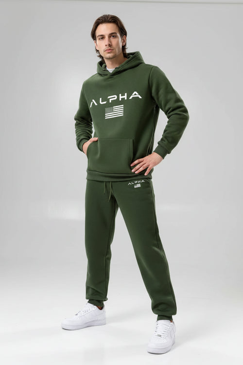 Person wearing a green Alpha tracksuit on a white background