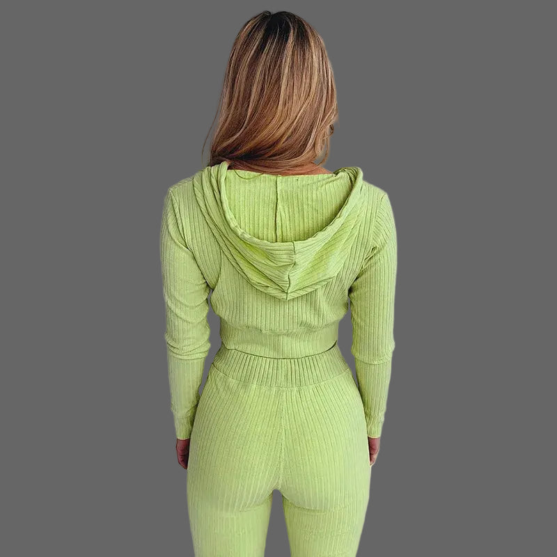 Person wearing a green ribbed knit outfit against a white curtain background