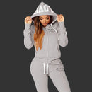Woman wearing a gray tracksuit with 'ITALIA' branding on a white background