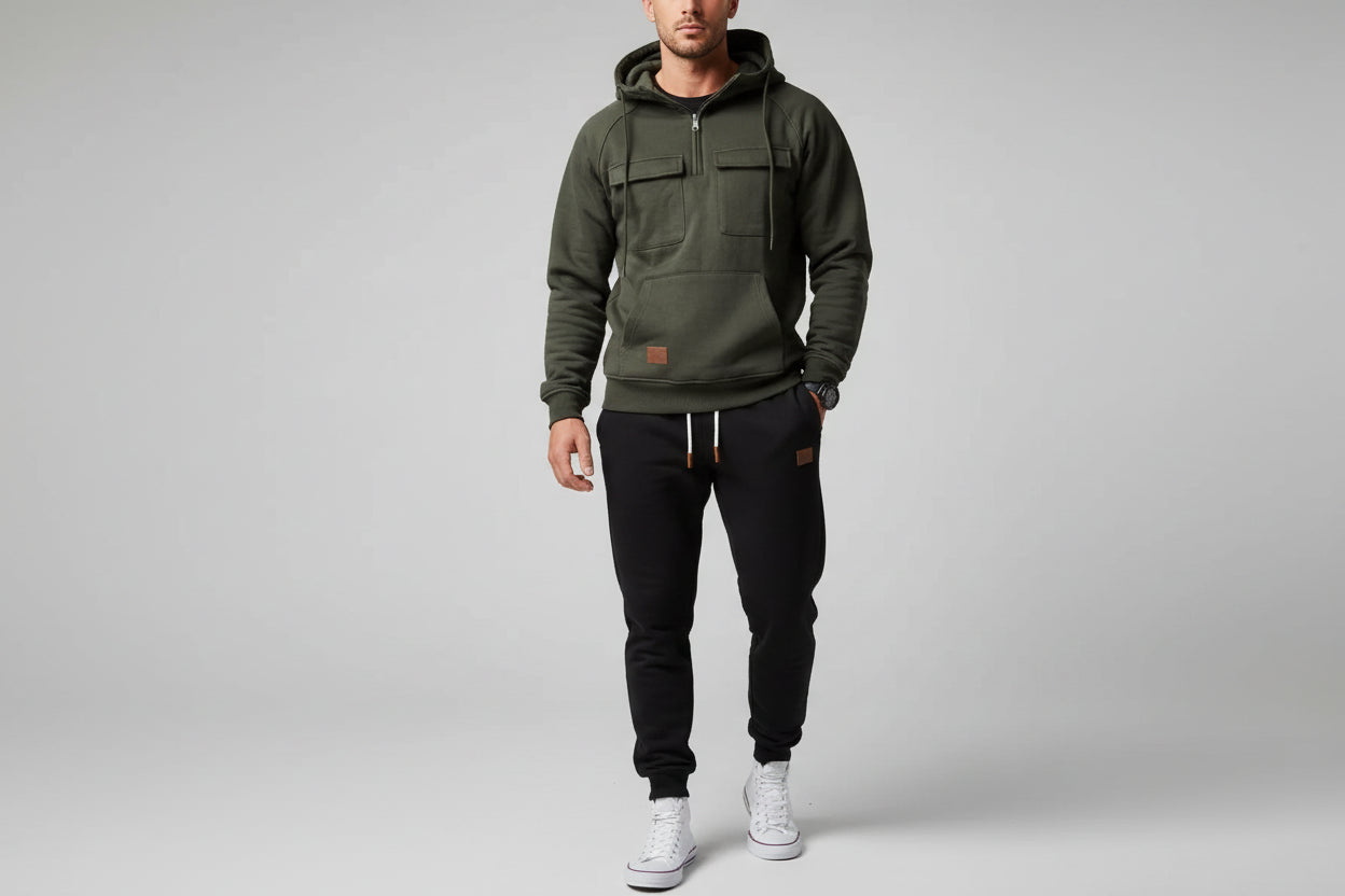 Dark gray hoodie and black pants with white sneakers on a gray background
