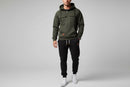 Dark gray hoodie and black pants with white sneakers on a gray background