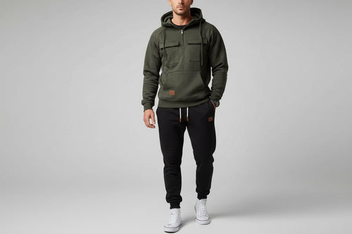 Dark gray hoodie and black pants with white sneakers on a gray background