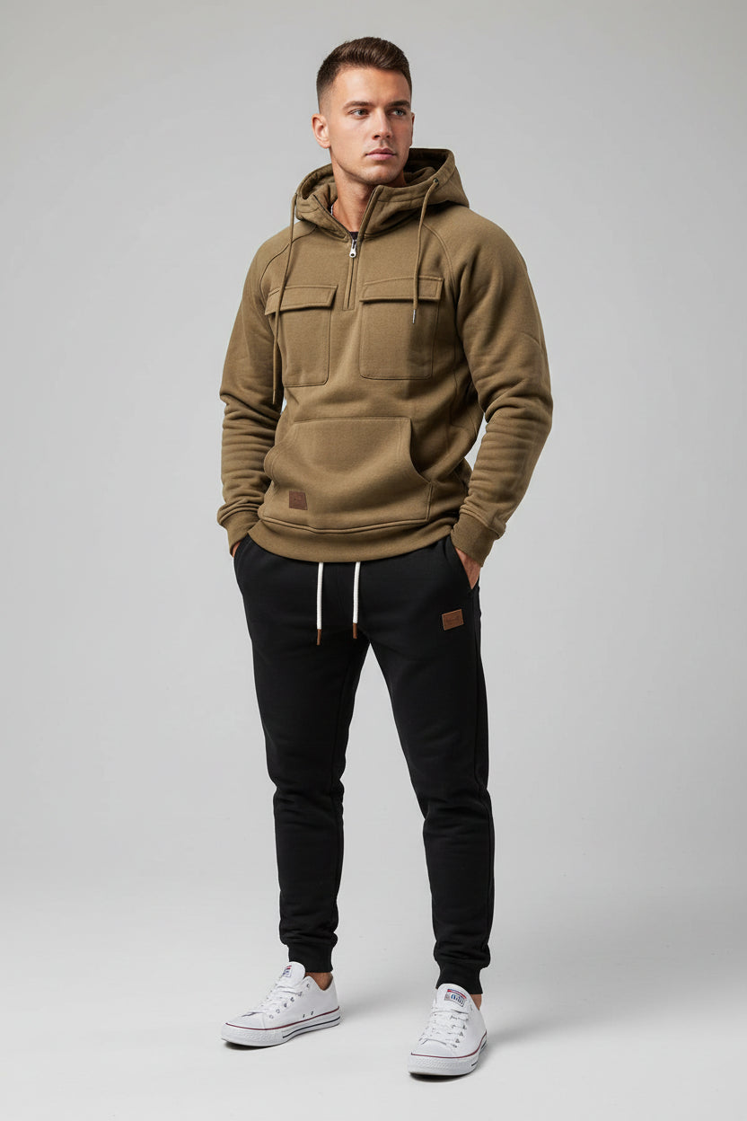 Brown hoodie and black pants with white sneakers on a gray background