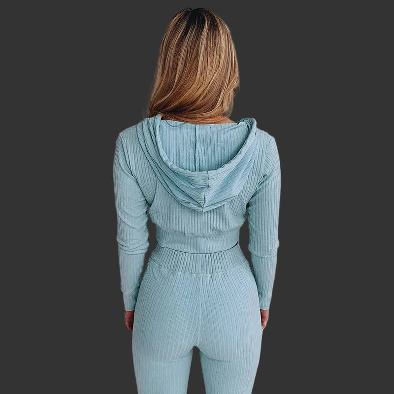 Person wearing a light blue ribbed hoodie and leggings set against a white background