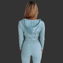 Person wearing a light blue ribbed hoodie and leggings set against a white background