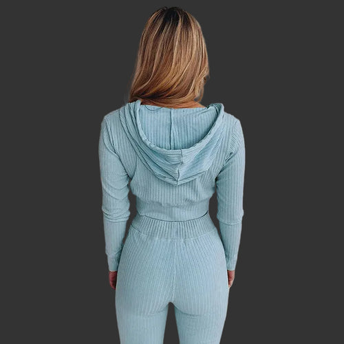 Person wearing a light blue ribbed hoodie and leggings set against a white background
