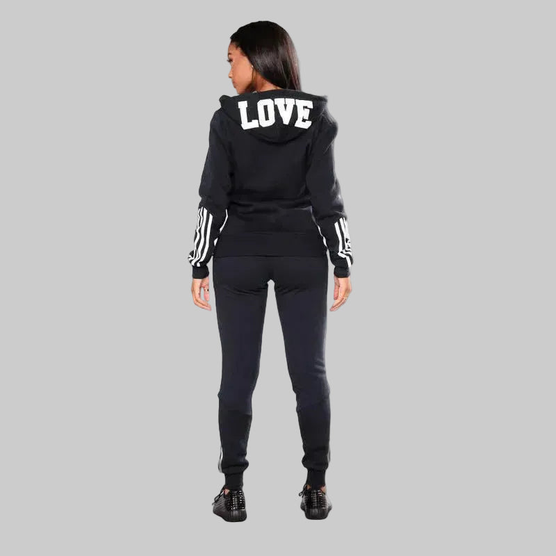 Person wearing a black tracksuit with 'LOVE' on the hood against a white background
