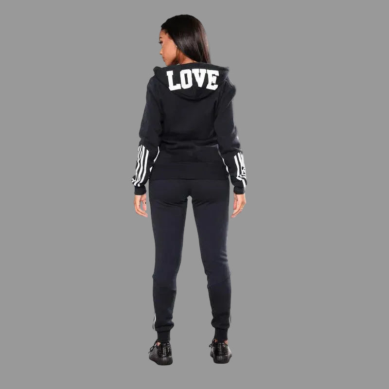 Person wearing a black tracksuit with 'LOVE' on the hood against a white background