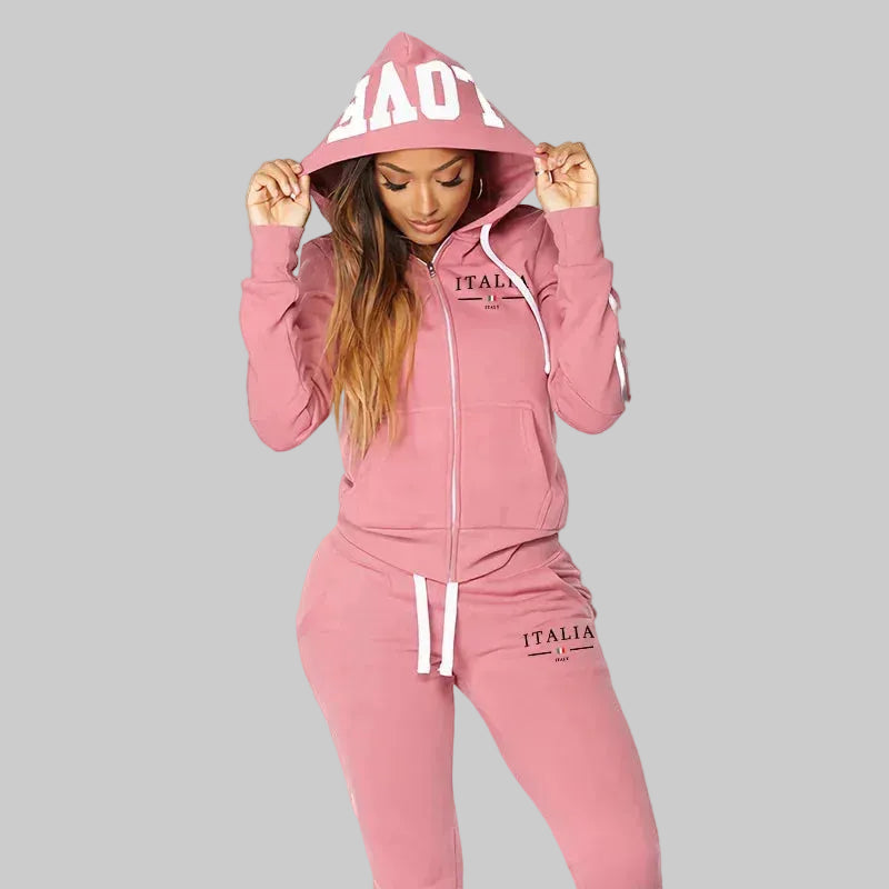 Pink tracksuit with 'ITALIA' branding worn by a model on a white background
