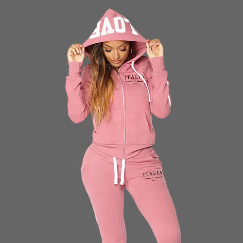 Pink tracksuit with 'ITALIA' branding worn by a model on a white background