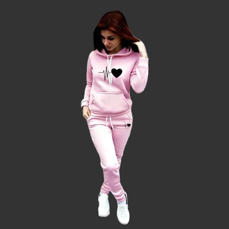 Woman wearing a pink tracksuit with a heart design on a gray background