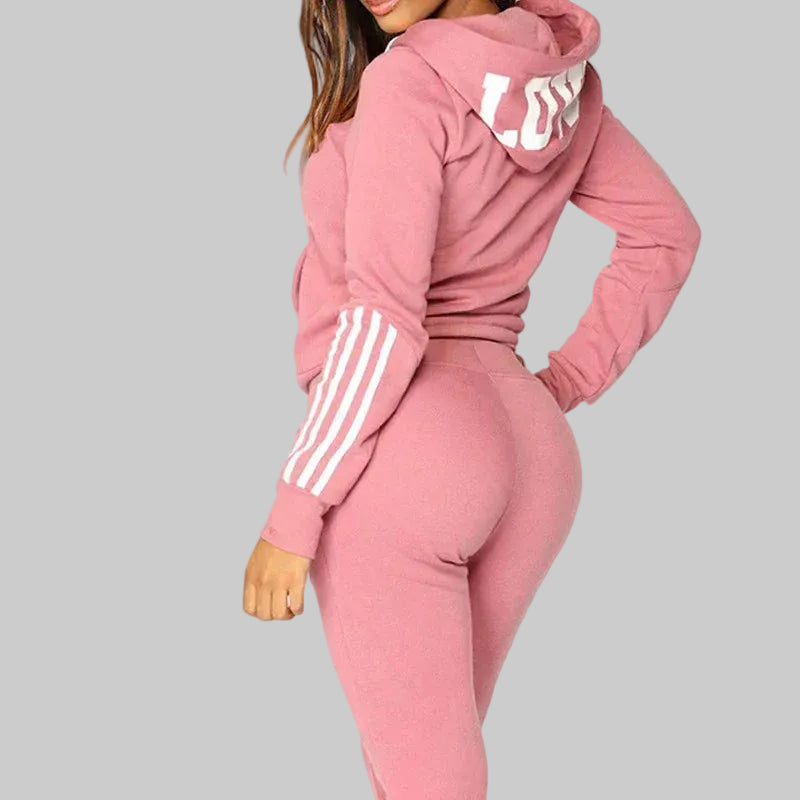 Pink tracksuit with white stripes on sleeves against a white background