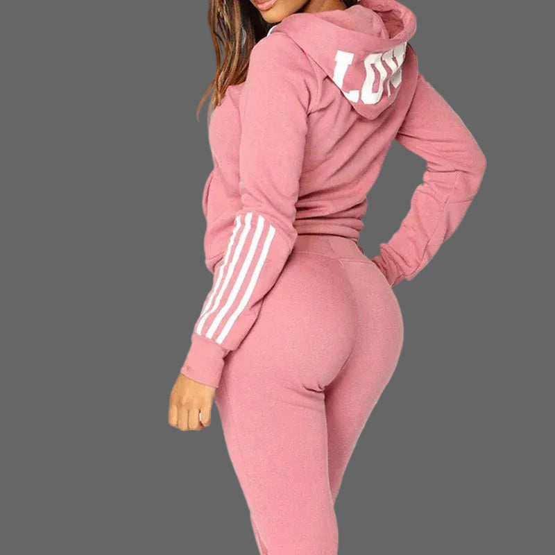 Pink tracksuit with white stripes on sleeves against a white background