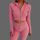 Pink ribbed tracksuit worn by a person on a white background