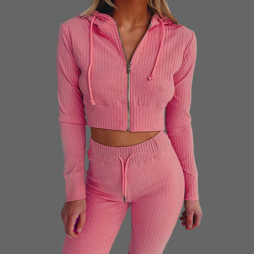 Pink ribbed tracksuit worn by a person on a white background