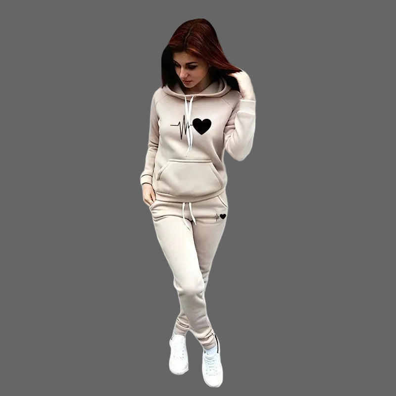 Woman wearing a beige tracksuit with a heart design on a gray background