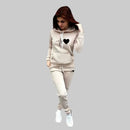 Woman wearing a beige tracksuit with a heart design on a gray background