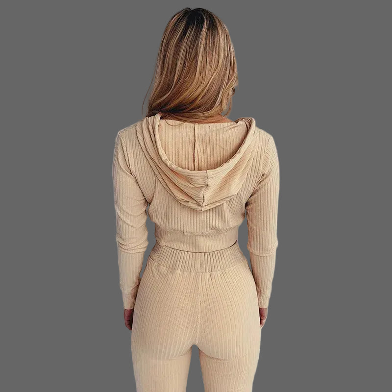 Person wearing a beige ribbed knit outfit against a white background
