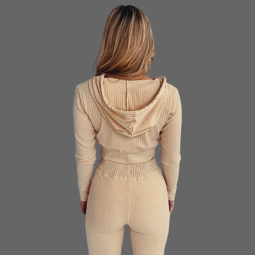 Person wearing a beige ribbed knit outfit against a white background