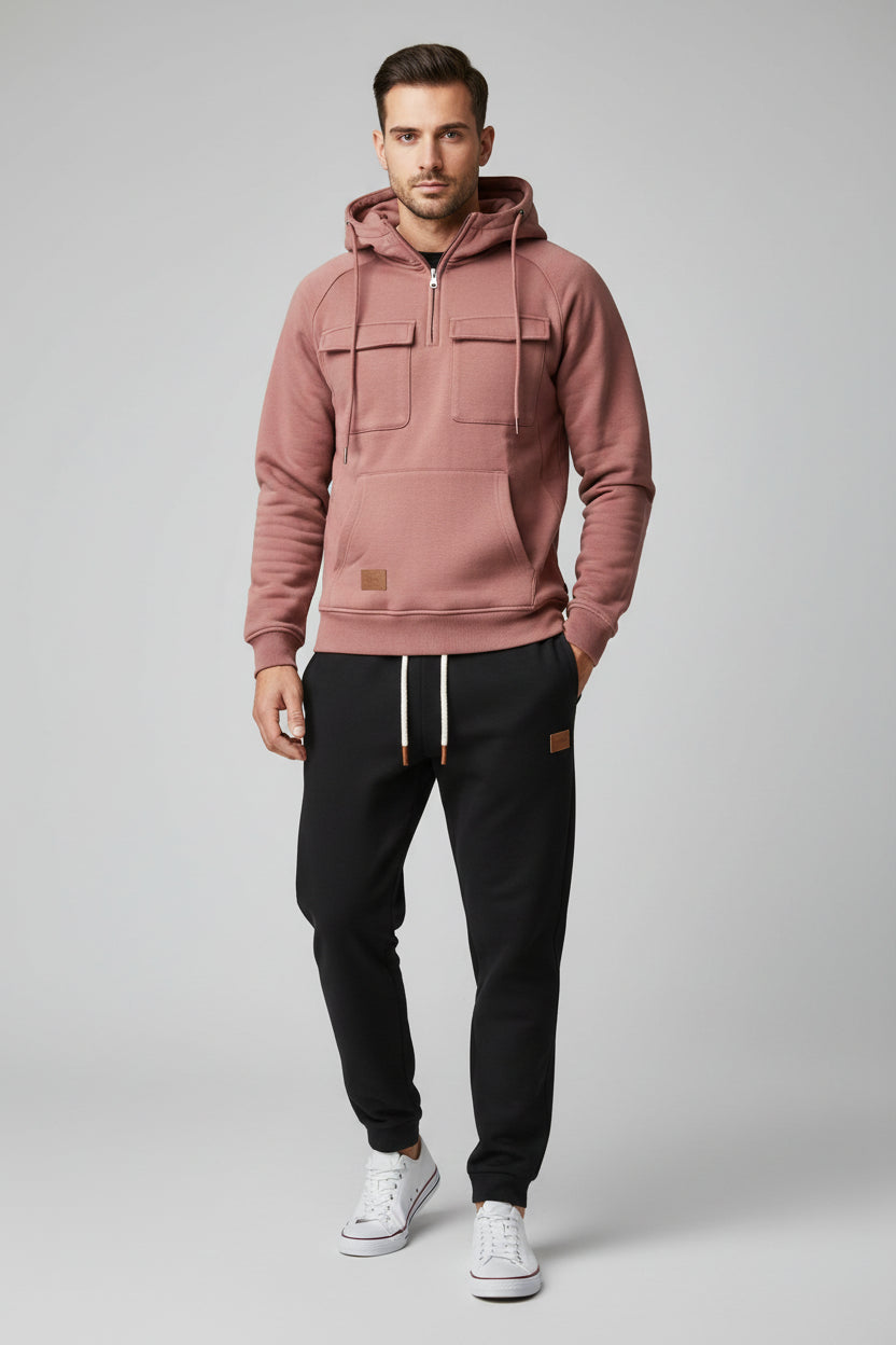Pink hoodie and black pants with white sneakers on a gray background