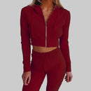 Red ribbed knit outfit with a cropped jacket and matching pants on a plain background