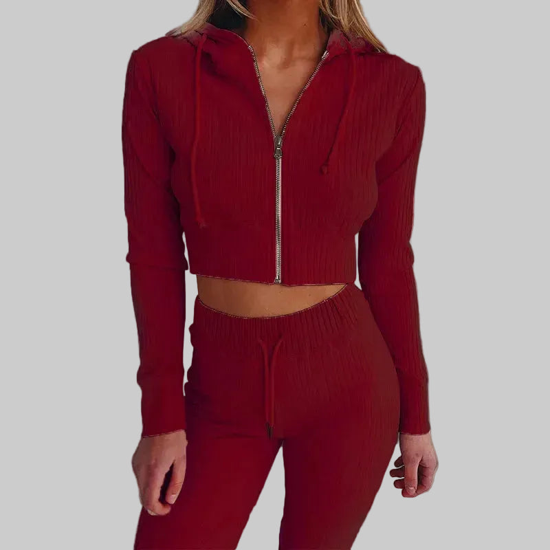 Red ribbed knit outfit with a cropped jacket and matching pants on a plain background
